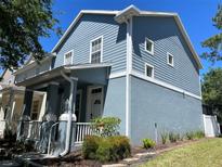 Charming two-story home featuring a light blue exterior with a welcoming front porch and manicured landscaping at 6327 Southbridge St, Windermere, FL 34786