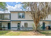 Charming townhome with covered entry, light siding, and tree in the front yard at 2652 Laser Ct, Orlando, FL 32826