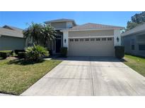 Charming single-Gathering home with a two-car garage and well-maintained landscaping and large driveway at 14220 Morning Frost Dr, Orlando, FL 32828