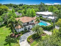 An aerial view displays the home's beautiful landscaping, unique driveway, and a tranquil setting at 2614 Parkland Dr, Winter Park, FL 32789