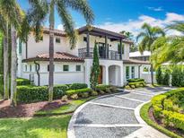 Elegant two-story home featuring a tile roof, balcony, and lush landscaping at 2614 Parkland Dr, Winter Park, FL 32789