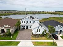Beautiful two-story home with paver driveway and solar panels near the lake and lush landscaping at 2926 Crest Wave Dr, Clermont, FL 34711
