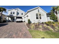 Charming two-story home with a well-maintained front yard and brick paver driveway at 2926 Crest Wave Dr, Clermont, FL 34711