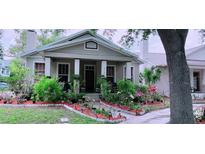 Charming single-story home with a cozy front porch and lush, colorful garden at 312 N Forest Ave, Orlando, FL 32803