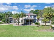Stately two-story home boasts manicured lawn, palm trees, and traditional architectural details at 980 Geryl Way, Deland, FL 32724