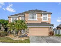 Charming two-story home featuring a stone-accented facade, a well-manicured lawn, and a two car garage at 1114 Landale Ct, Orlando, FL 32828