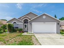 Charming single-story home with well-manicured lawn and attached two-car garage at 13624 Springtide Ct, Orlando, FL 32826