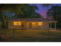 Charming home with a cozy front yard and welcoming entrance, illuminated by warm light at dusk at 1531 Jefferson Dr, Mount Dora, FL 32757
