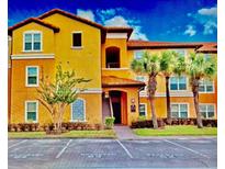 Inviting condo with well-maintained landscaping and vibrant yellow facade at 5471 Vineland Rd # 7109, Orlando, FL 32811