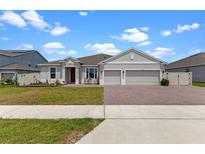 Charming single-story home featuring a two-car garage, brick-paved driveway, and well-manicured lawn at 5981 Sierra Crown St, Mount Dora, FL 32757