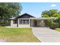 Charming single-story home with a carport, featuring a well-maintained lawn and mature trees at 207 Rose St, Auburndale, FL 33823