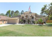 Charming single Gathering home with landscaped front yard and attached garage with large lawn and American flag at 3200 Town And Country Rd, Oviedo, FL 32766