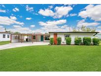 Charming single story home featuring a lush lawn, inviting curb appeal, and a covered carport at 3713 Dover St, Orlando, FL 32806