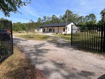 Charming single story home with a black metal fence and mature trees at 456 Baron Rd, Orlando, FL 32828