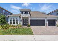 Beautiful two-story home with a three car garage, well-manicured lawn, and stone accents at 4779 Cragmere Loop, Clermont, FL 34711