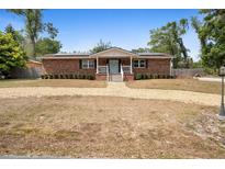Charming single-story brick home featuring a gravel driveway, mature trees, and a welcoming front porch at 617 E Citrus St, Altamonte Springs, FL 32701