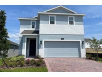 Charming two-story home featuring a brick driveway and attached two-car garage at 6712 Golden Eagle Blvd, Howey In The Hills, FL 34737