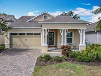 Charming single-story home featuring a manicured lawn, front porch, and an attached two-car garage at 7748 Four Seasons Blvd, Kissimmee, FL 34747