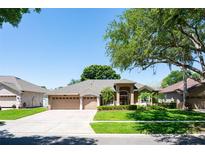 Beautiful single-story home with a three-car garage and well-manicured lawn at 8037 Bangle Ln, Orlando, FL 32836