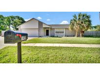Charming single-story home with stone accents, lush lawn, and mature palm trees at 1458 Heather Way, Kissimmee, FL 34744