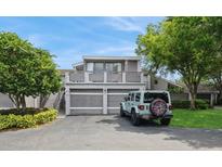 Two-story home with attached garage and deck situated in a landscaped front yard with a clear blue sky at 5125 Cypress Creek Dr # 2, Orlando, FL 32811