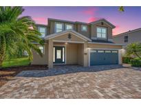 Beautiful two-story home with a two-car garage and a well-manicured brick driveway at 7644 Fairfax Dr, Kissimmee, FL 34747