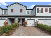 Beautiful townhome featuring a brick driveway, attached garage, and neutral paint at 308 Rustic Loop, Sanford, FL 32771