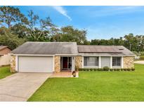 Charming single-story home with stone accents, well-manicured lawn, solar panels, and attached garage at 819 Haulover Dr, Altamonte Springs, FL 32714