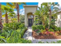 Charming front entrance with lush landscaping and inviting walkway to the front door at 12636 Hammock Pointe Cir, Clermont, FL 34711
