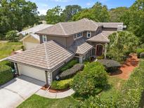 Beautiful home exterior featuring a neutral color, tile roof, manicured landscaping, and a two-car garage at 14037 Fairway Willow Ln, Winter Garden, FL 34787