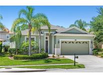 Charming single-story home with lush landscaping, mature palm trees, and a well-manicured lawn at 14137 Queenside St, Orlando, FL 32824