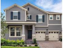 Charming two-story home with gray siding, black shutters and two-car garage at 16124 Azure Key St, Winter Garden, FL 34787