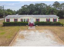 Charming single-story home with red shutters, landscaped hedges, and spacious driveway at 18906 Merrich Rd, Orlando, FL 32820