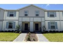 Charming townhome featuring a neutral color scheme, welcoming entrance, and well-maintained landscaping at 3806 Lana Ave, Davenport, FL 33897
