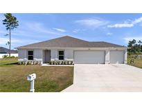 Inviting single-story home with a well-maintained lawn and a three-car garage at 4743 Sw 114Th Pl, Ocala, FL 34476