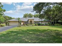 Charming single Gathering home with a lush green lawn and beautifully landscaped front yard at 7779 Lake Andrea Cir, Mount Dora, FL 32757