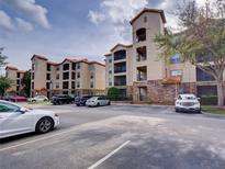 Exterior view of condo building featuring multiple levels and ample parking at 8000 Tuscany Way # 4408, Davenport, FL 33896