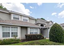 Charming exterior view of a home with a well-maintained lawn, lush green shrubbery and neutral color scheme at 127 Lake Emma Cove Dr # 127, Lake Mary, FL 32746