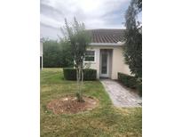 Charming single-story home featuring a tiled roof, a landscaped yard, and a welcoming front entrance at 2300 Painter Ln, Kissimmee, FL 34741