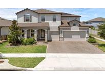 Beautiful two-story home with a three-car garage and well-maintained lawn and paver driveway at 2751 Matera Dr, St Cloud, FL 34771