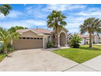 Charming single-Gathering home featuring a manicured lawn and mature palm trees at 3016 Samosa Hill Cir, Clermont, FL 34714