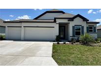 Charming single-story home featuring a three-car garage and a well-manicured lawn at 4009 Maggie Loop, Lakeland, FL 33813
