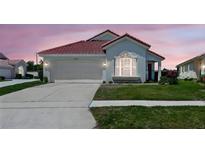 Inviting single-story home with a two-car garage, well-kept lawn, and charming architectural details at 751 Via Milano, Apopka, FL 32712