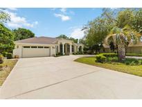 Stunning single-story home with a sprawling driveway, attached garage, and lush landscaping at 1320 Antrim Cir, Ormond Beach, FL 32174