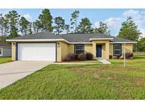 Charming single-story home featuring a two-car garage, well-maintained lawn, and lovely landscaping at 13489 Sw 60Th Avenue Rd, Ocala, FL 34473