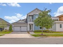 Charming two-story home featuring a two-car garage, balcony, and beautifully landscaped front yard at 14559 Walcott Ave, Orlando, FL 32827