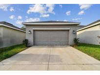 Attached garage with a wide driveway and manicured lawn provides convenience at 15210 Chapter Way, Winter Garden, FL 34787
