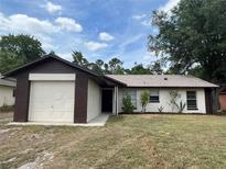 Charming single-story home featuring an attached garage, tidy landscaping and a well-maintained lawn at 288 Howard Blvd, Longwood, FL 32750