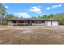 Charming exterior of home features a covered porch and a two-car garage at 424 Eden Park Rd, Altamonte Springs, FL 32714