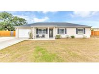 Charming single-story home featuring a well-manicured lawn and a cozy front porch seating area at 5904 Lakewood Ln, Lakeland, FL 33805